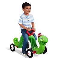 boy riding the green inchworm smiling