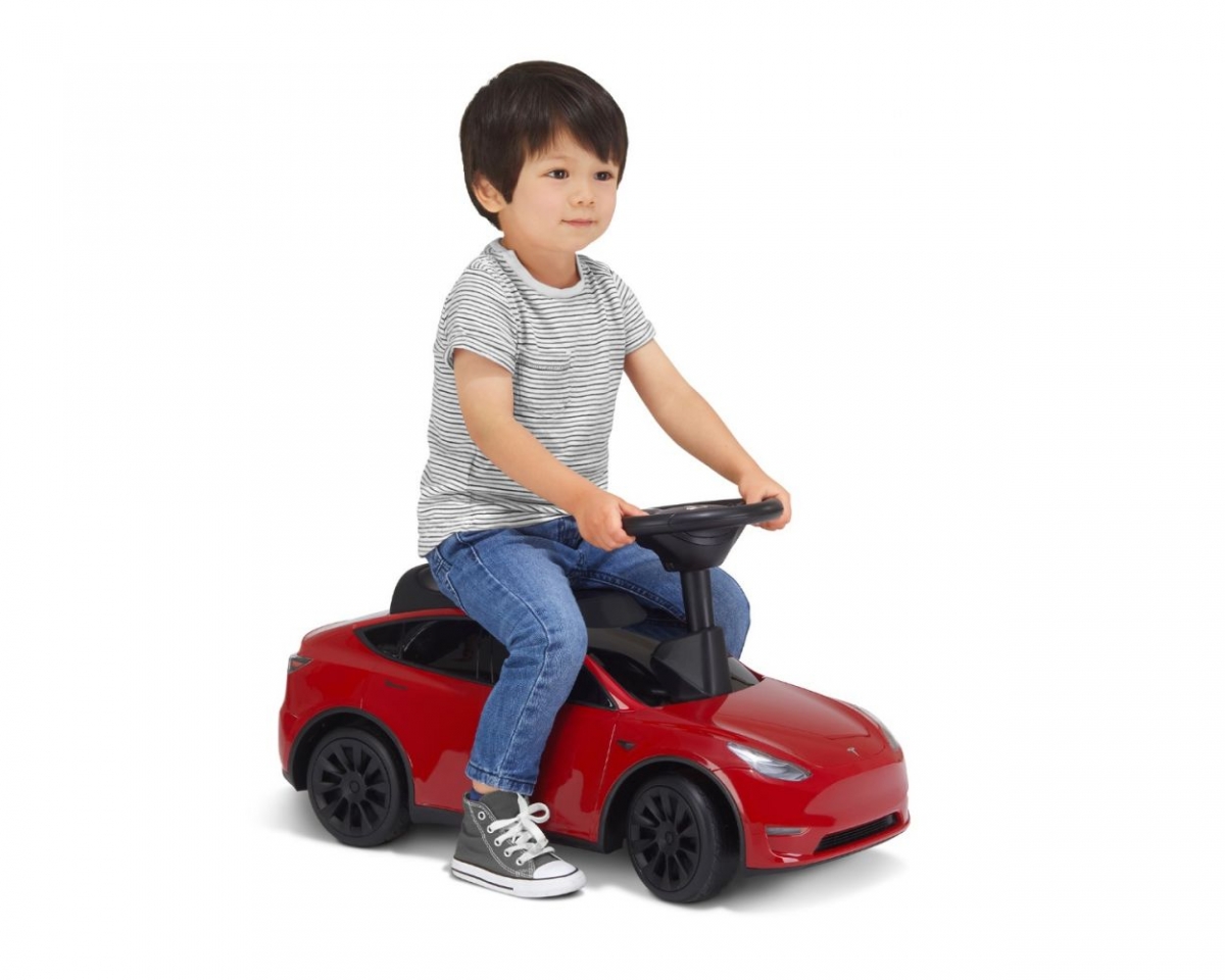 child on tesla ride on toy