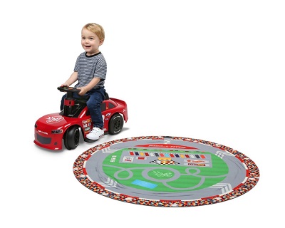 boy riding the Super Speedway Racer around the included circle racetrack playmat